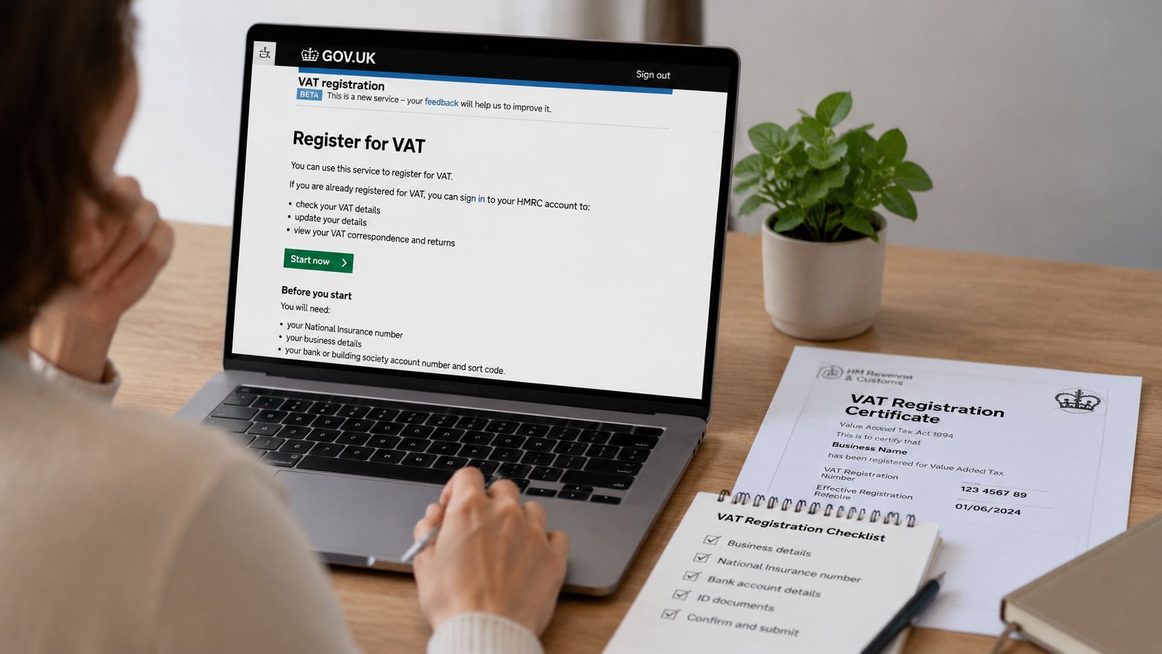 A person working on a laptop to register for VAT with a checklist and certificate nearby.